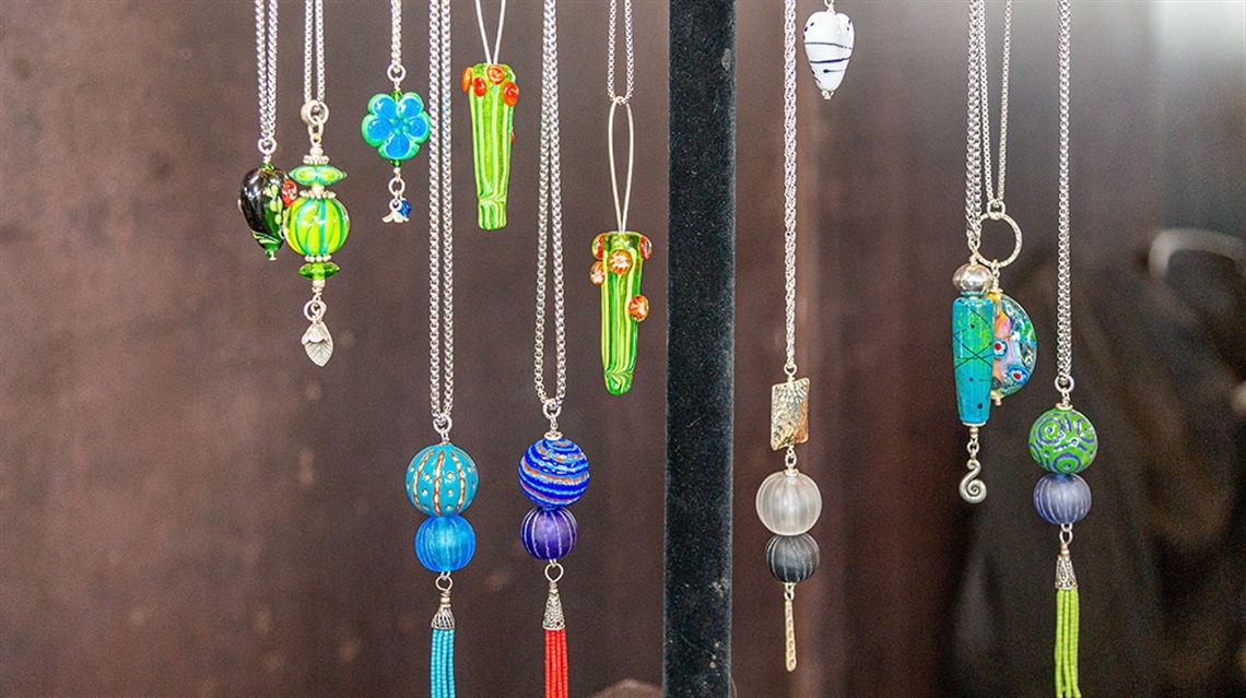 necklaces with glass beads hanging on rack