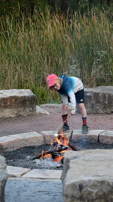 Boy roasting marshmallow on campfire
