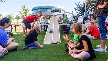 Crowd watches vegetable racecars travel down the track