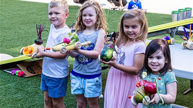 Four kids hold winning racecars