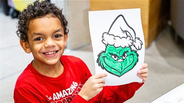 Boy shows off The Grinch coloring sheet