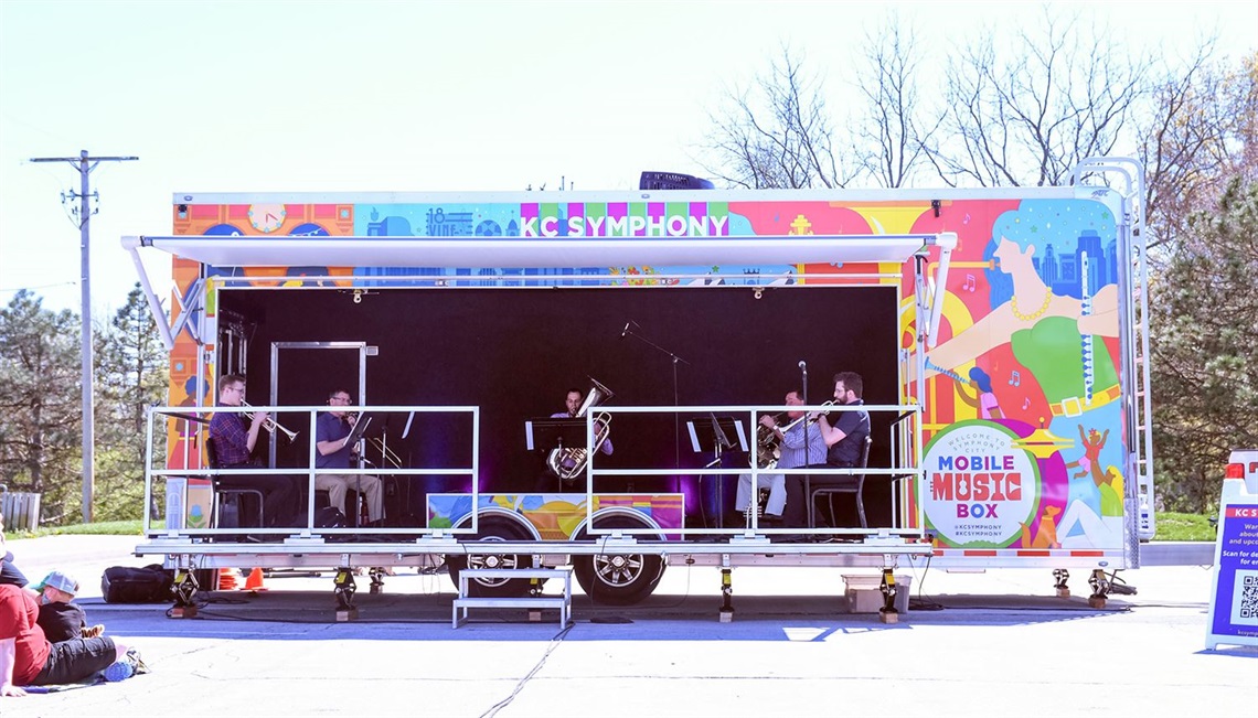 musicians playing on colorful mobile stage