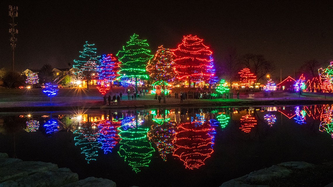 Sar-Ko Aglow decorated trees at far side of pond