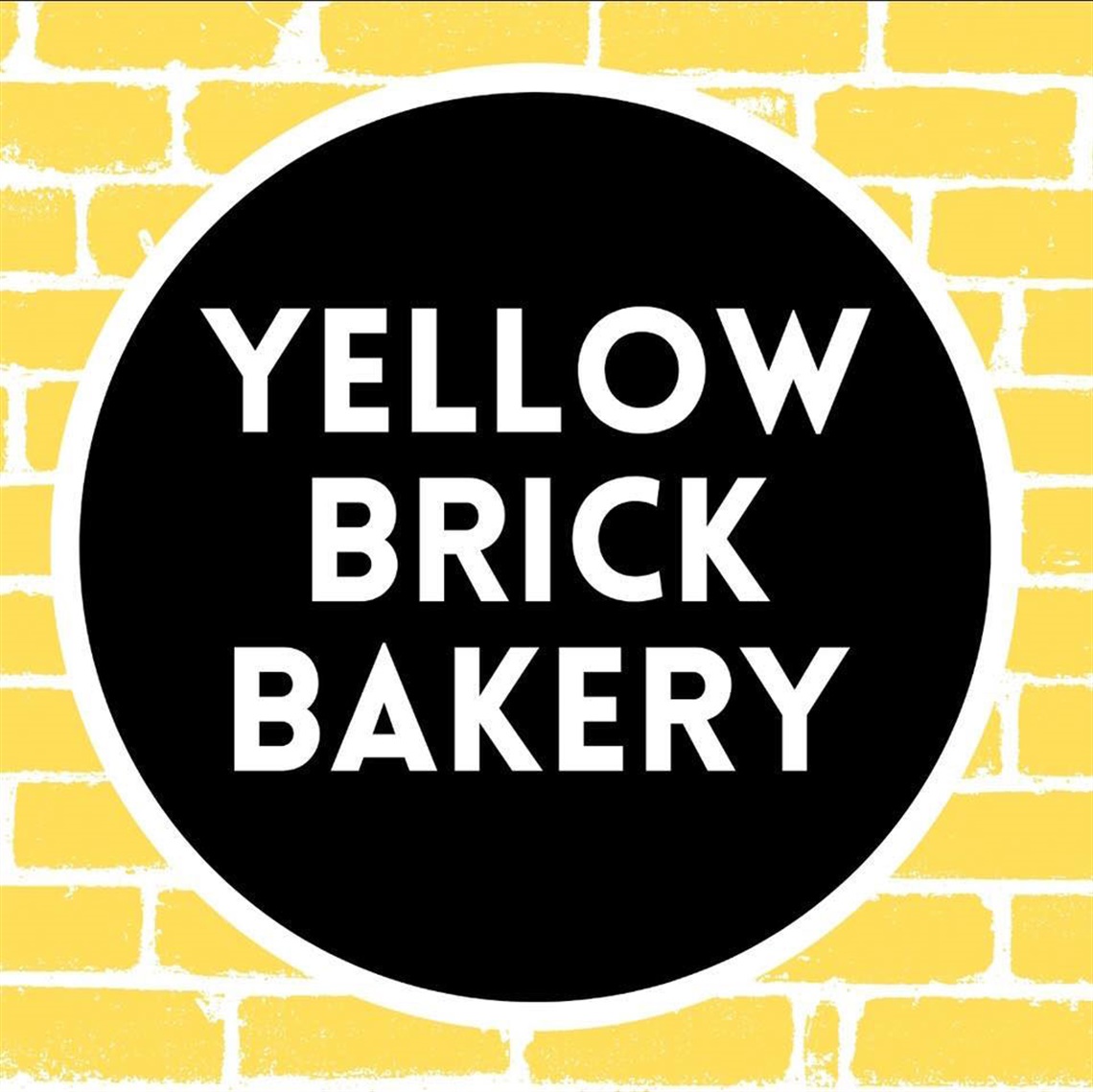 Yellow Brick Bakery logo in black circle against yellow brick pattern background