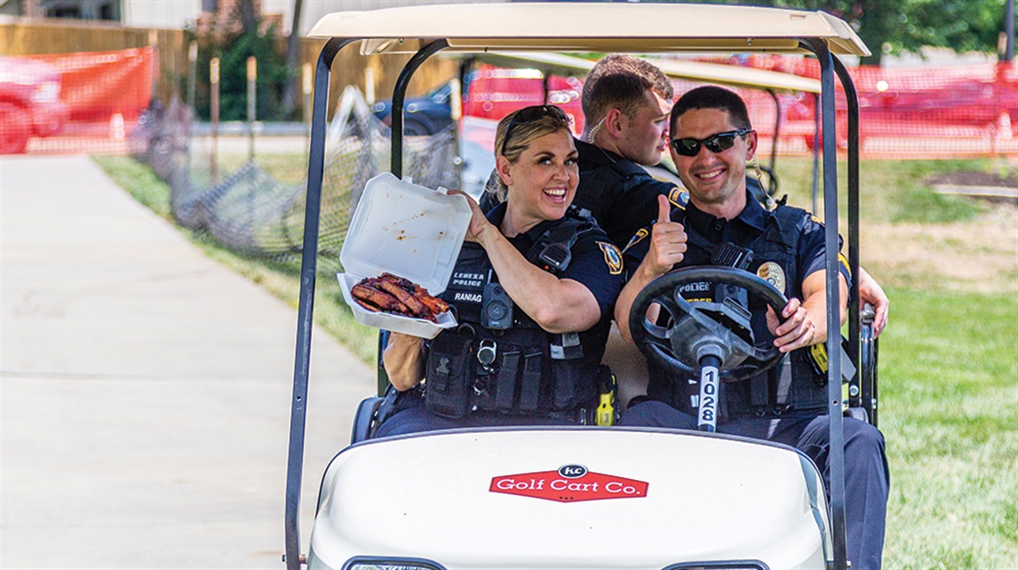 police officers with BBQ riding in golf cart