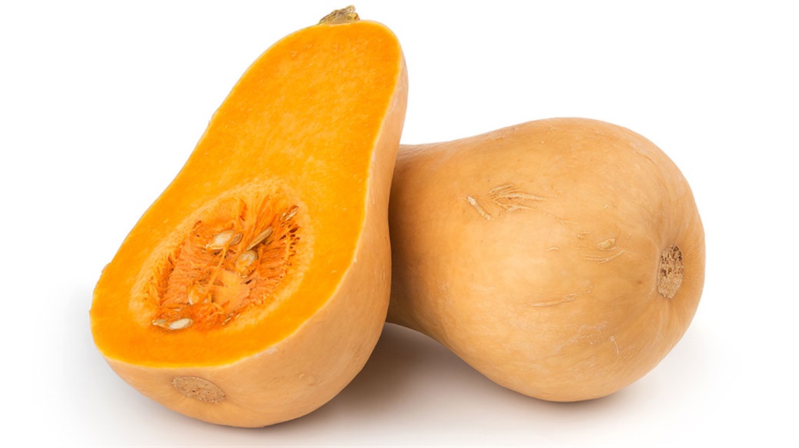 Butternut squash sliced lengthwise with one half leaning against the other