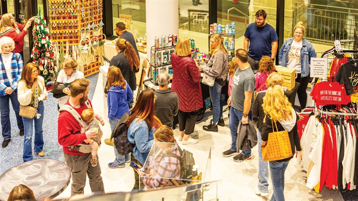 Shoppers inside Lenexa City Hall browsing holiday decor, crafts and handmade items