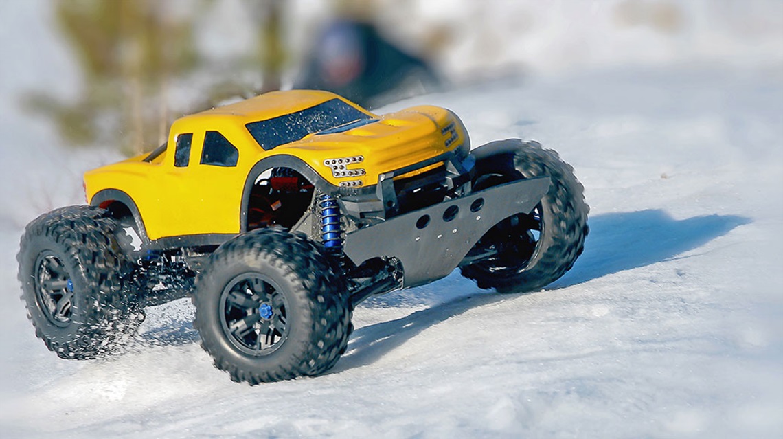 Remote control yellow monster truck riding on snow