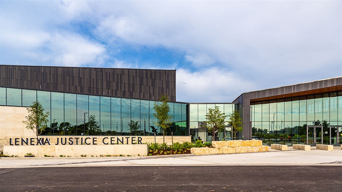 Two police staff standing in front of Lenexa Justice Center building